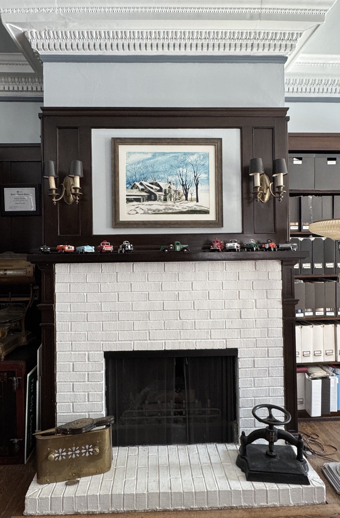 Library with Arts and Crafts brick-faced fireplace and built-in cabinets